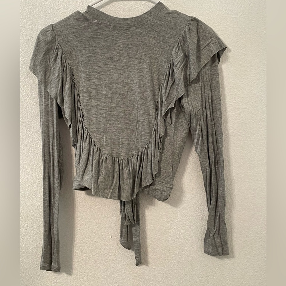 This is a gray long sleeve T-shirt with ruffles in an open back